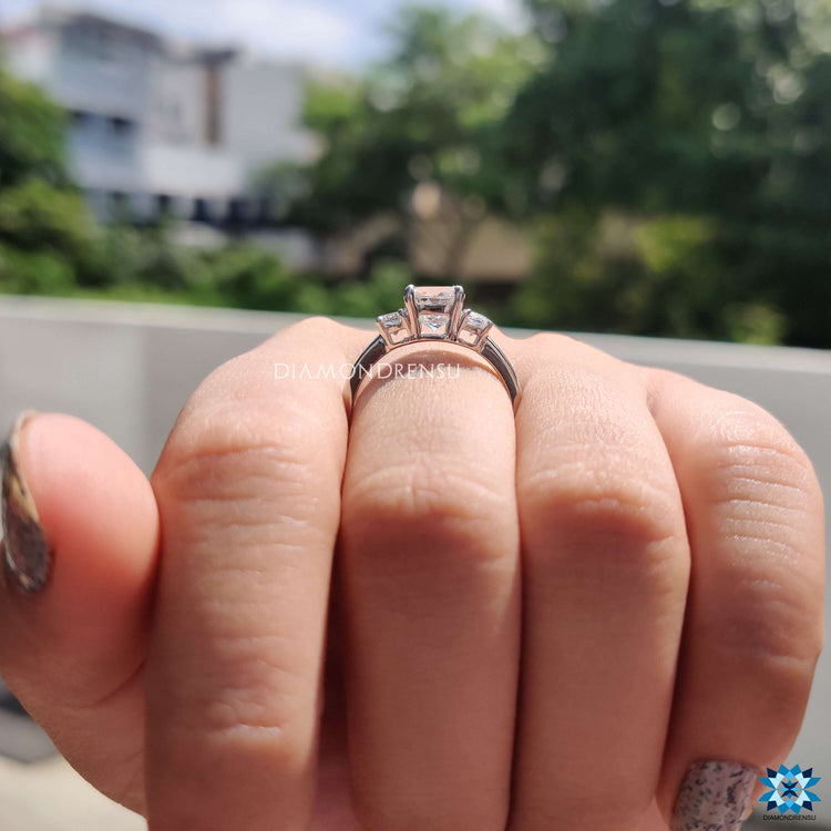 Four prong setting ring with cushion center and side accents.
