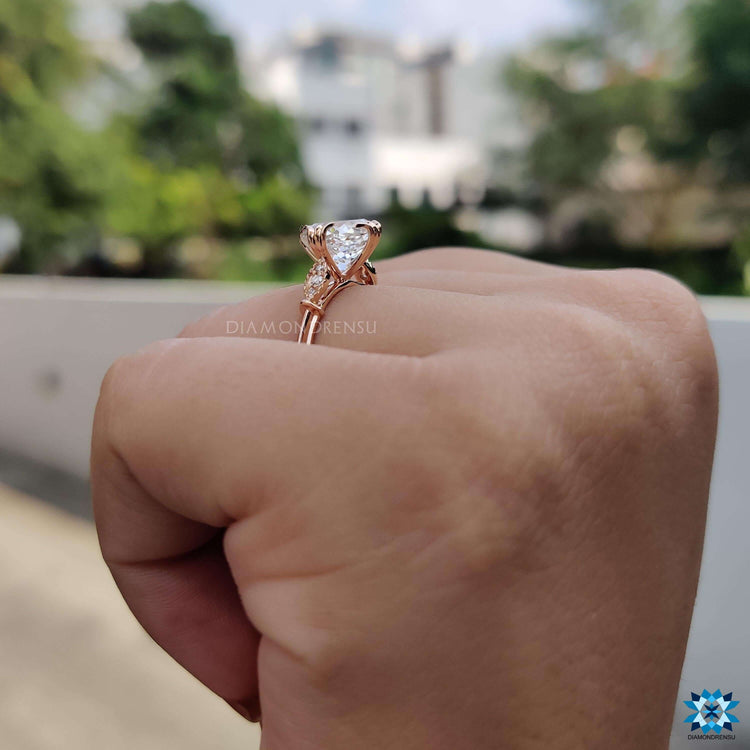 Rose gold ring with round side stones and milgrain edges.
