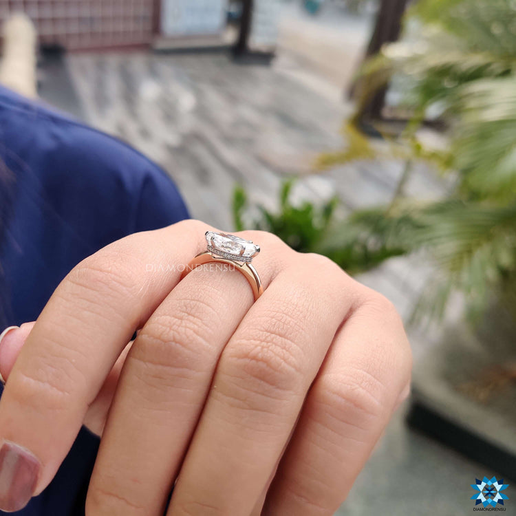Engagement ring with V prong marquise center and dual tone band.
