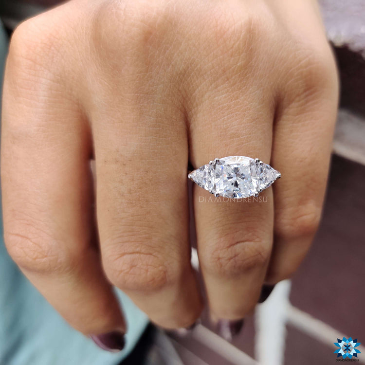 White gold engagement ring with cushion and trillion cut moissanites.
