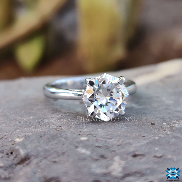 Tab prong solitaire ring featuring octagon cut moissanite.
