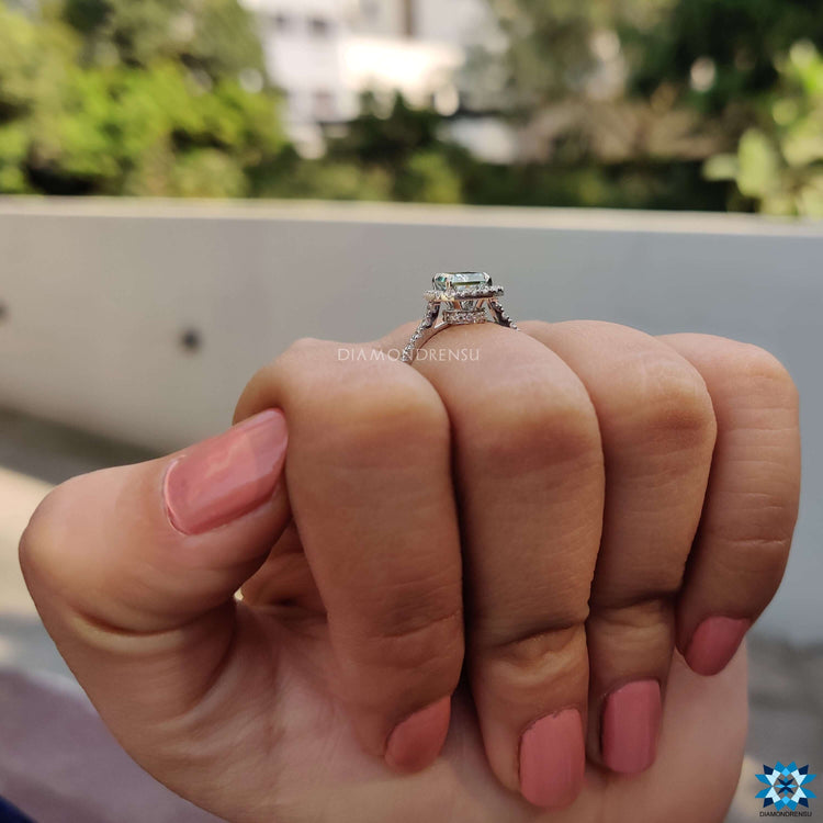 Cyan blue radiant engagement ring in a white gold setting with side stones.
