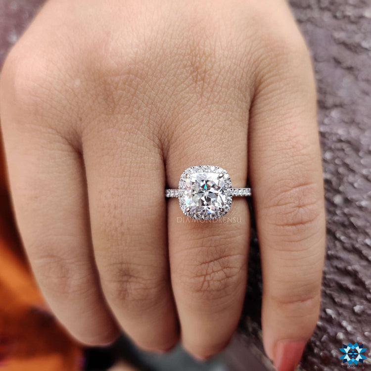 White gold engagement ring featuring a cushion Rensu cut center.
