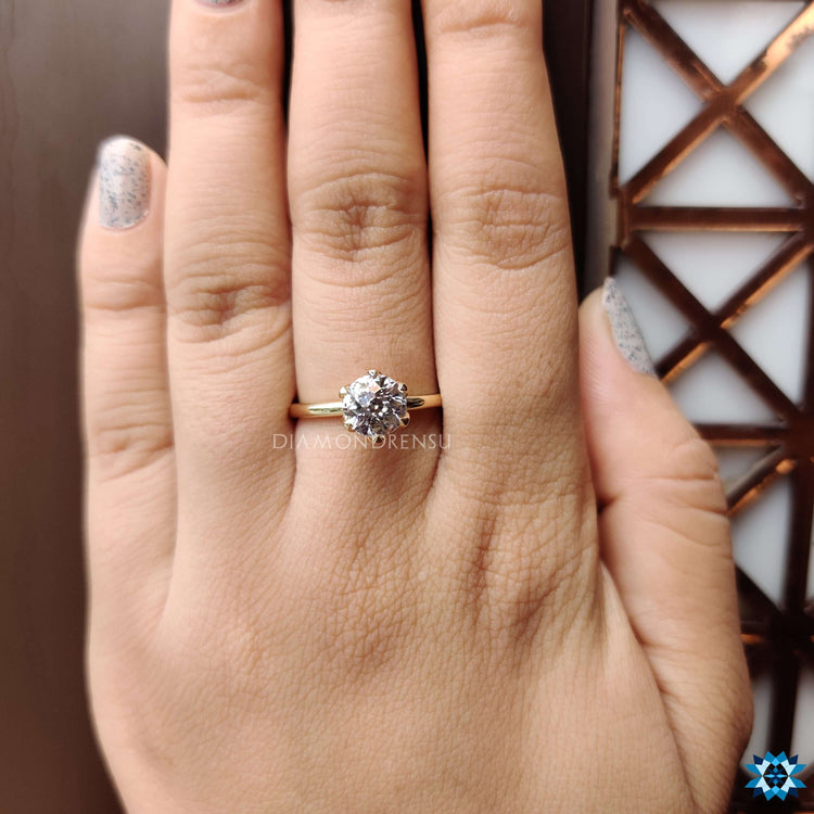 Yellow gold engagement ring featuring round moissanite.
