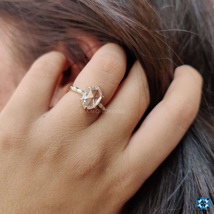 Yellow gold ring with oval moissanite and marquise side stones.
