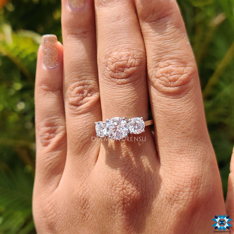 White gold engagement ring with three moissanite stones.
