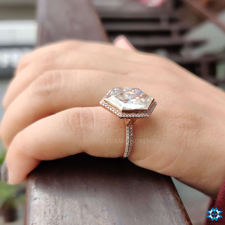 Rose gold moissanite ring with geometric halo design.
