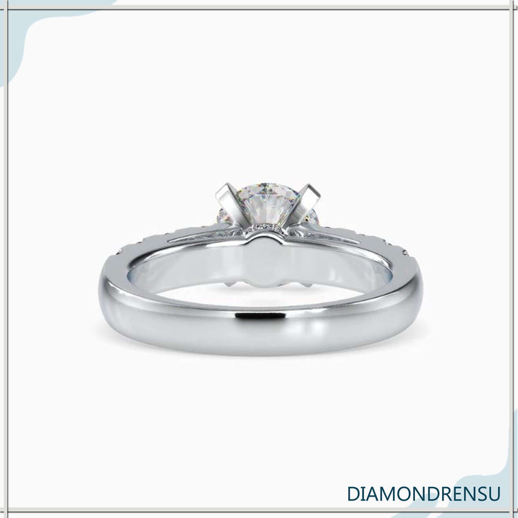 Yellow gold engagement ring with tab prong and halo detail.
