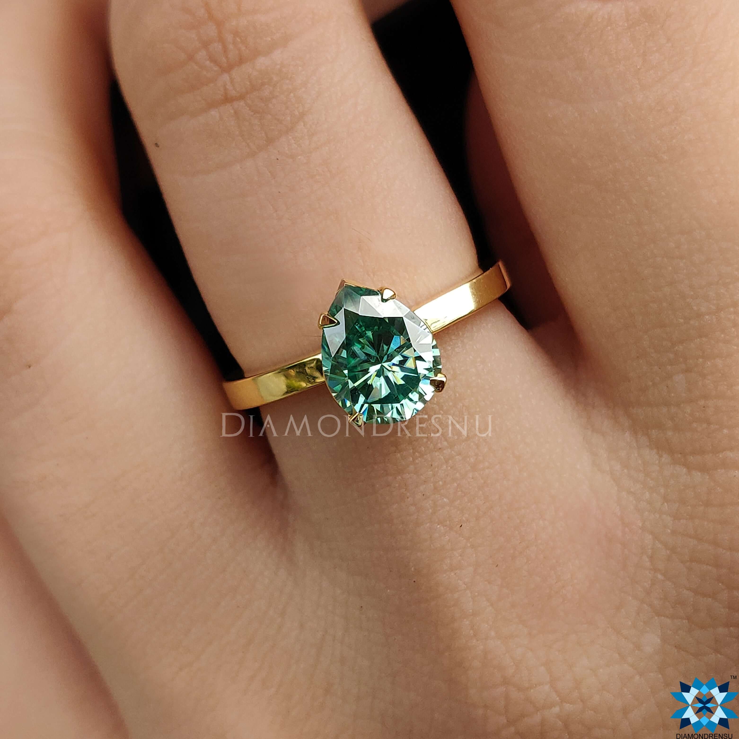 Green moissanite ring in a unique pear solitaire engagement design.