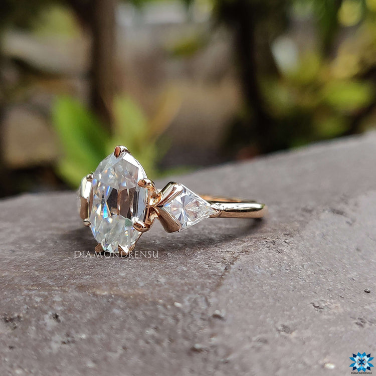 Oval center stone with kite accents in rose gold ring.
