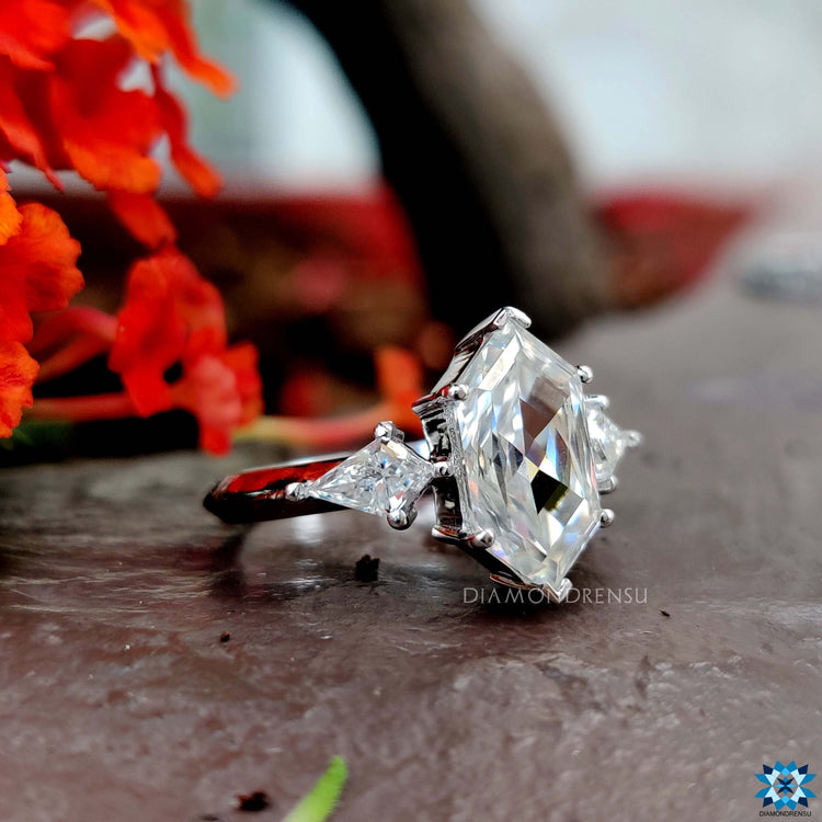 Handmade ring with elongated hexagon moissanite and kite cut accents in white gold.
