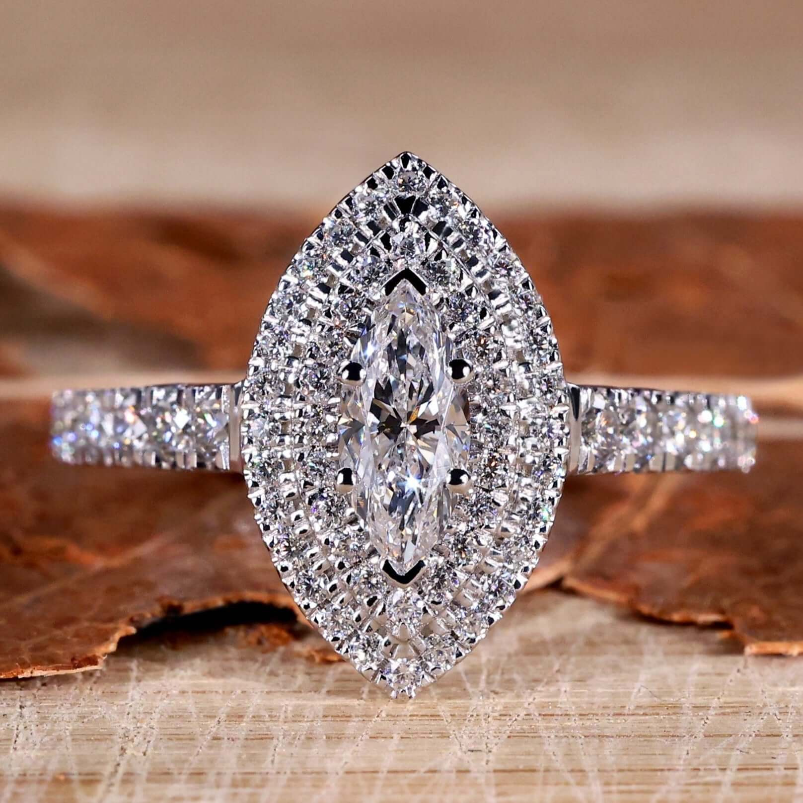 Marquise diamond ring with pave diamond accents in a unique engagement ring design.
