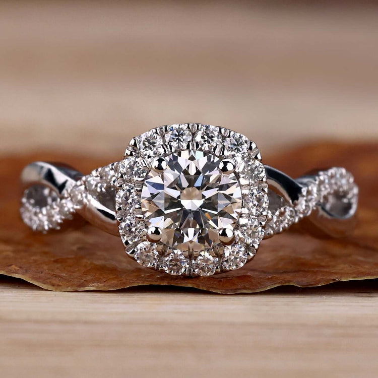 Twisted engagement ring with a round diamond, featuring a stunning halo ring setting for timeless elegance.
