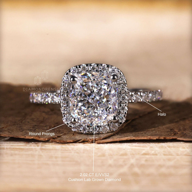 Halo ring paired with a cushion cut diamond and pave set band for enhanced brilliance.
