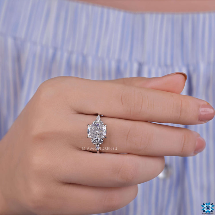7 stone engagement ring with cushion cut center in prong setting.
