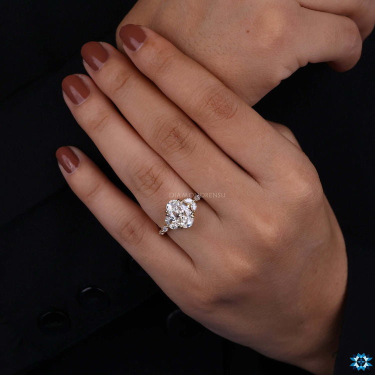 Marquise and round cut side stone ring in yellow gold with Rensu center.
