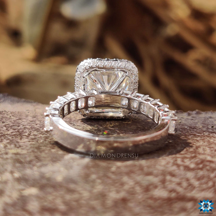 Custom engagement ring with square radiant center and halo of round stones.

