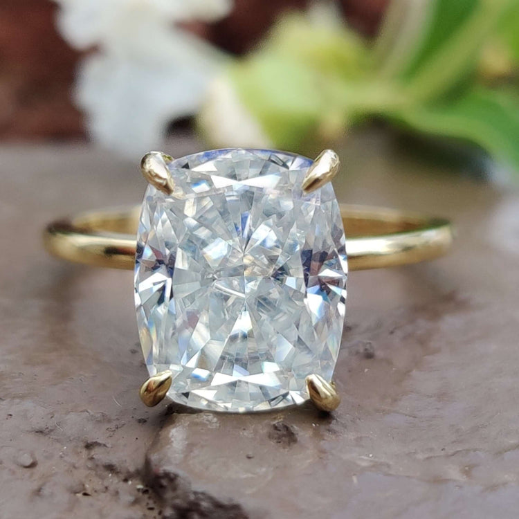 Elongated cushion cut ring in a solitaire setting with crushed ice moissanite.
