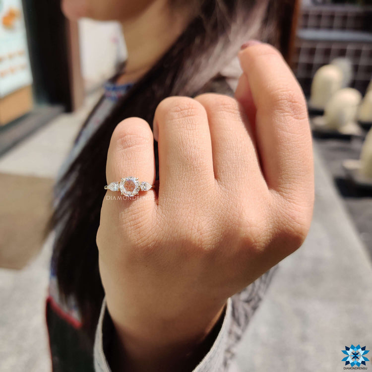 Three stone ring with round center and pear side stones.
