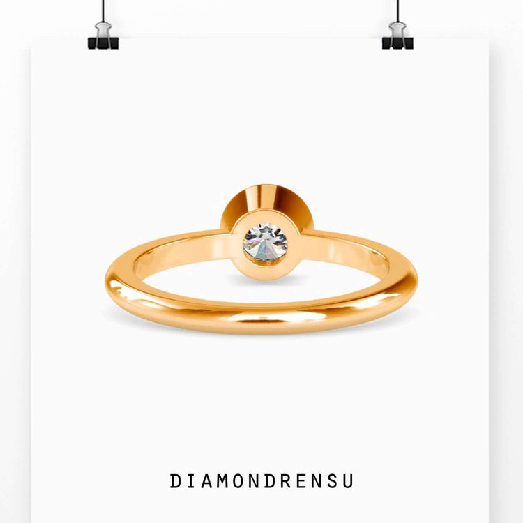 Lab grown diamond solitaire ring in yellow gold bezel mount.
