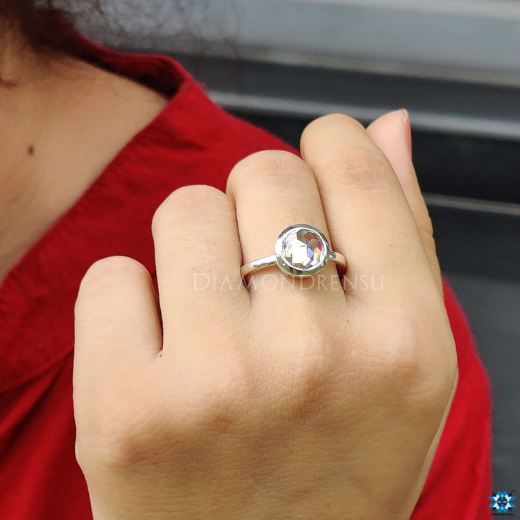 White gold bezel engagement ring featuring custom round rose cut Moissanite.
