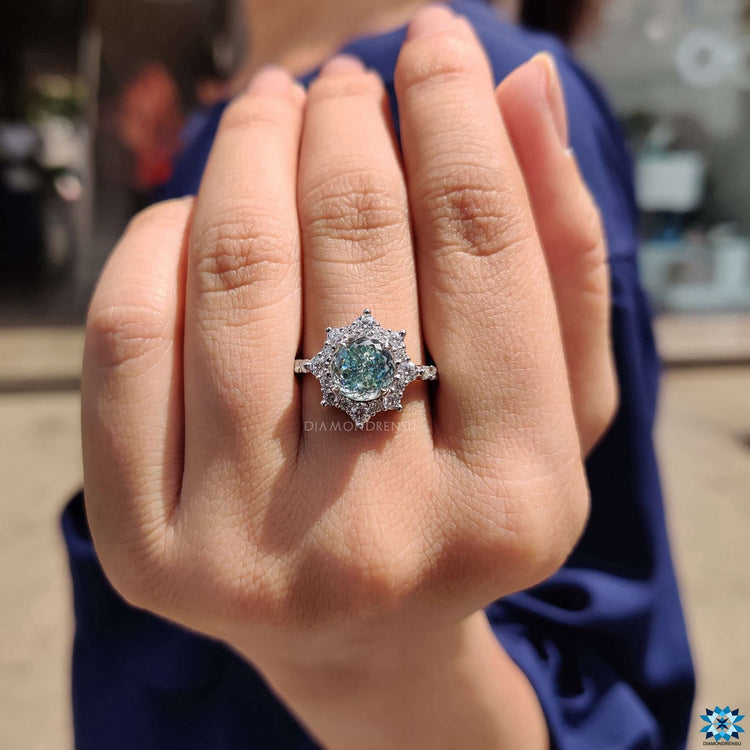 Blue moissanite halo ring in a handcrafted design.
