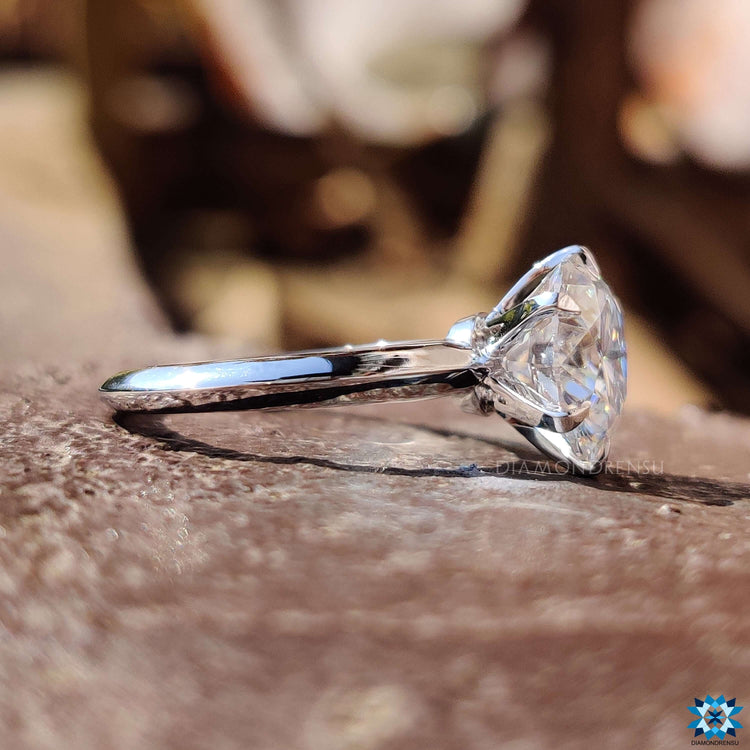 White gold round moissanite ring with knife edge band.

