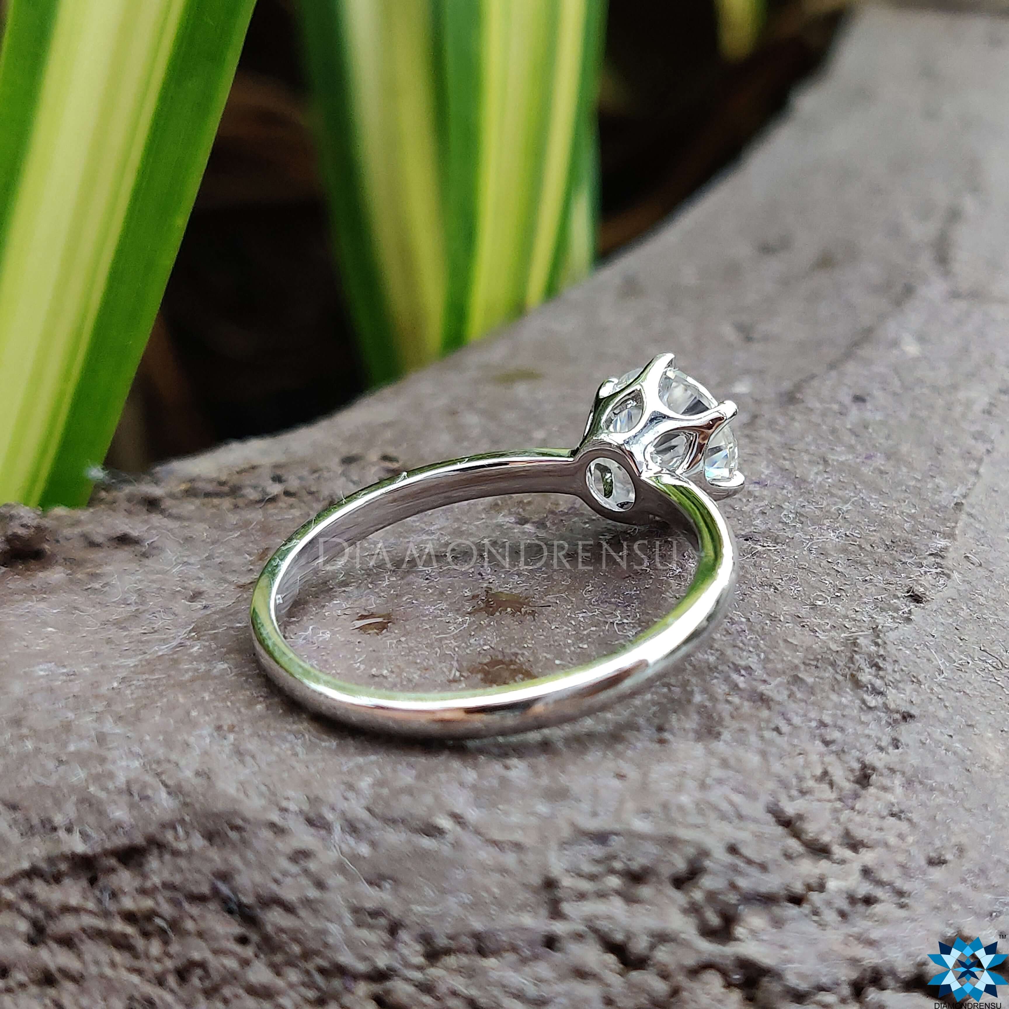 Round cut moissanite ring set in a sleek basket setting ring for added elegance.