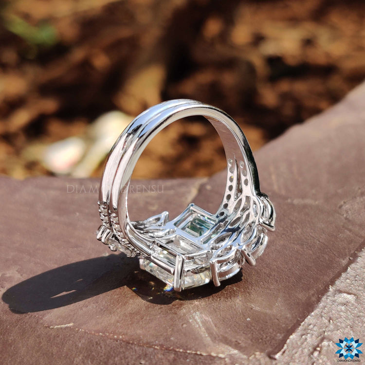 Muse setting ring design with emerald center stone.
