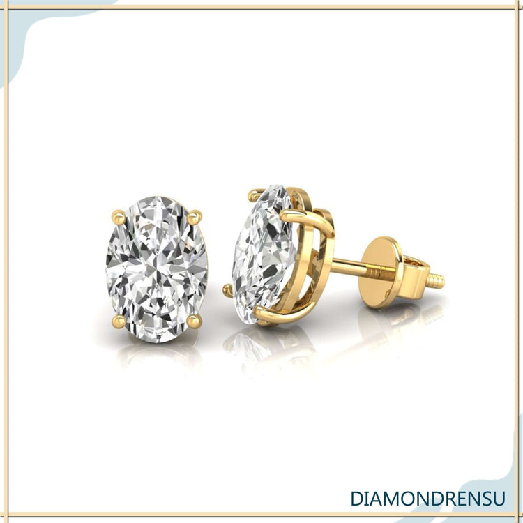 UK diamond earrings in gold with oval cut diamonds and basket setting.
