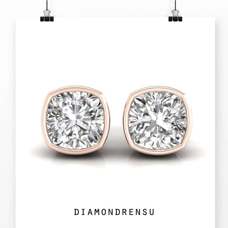 Gold diamond earrings in cushion bezel layout.
