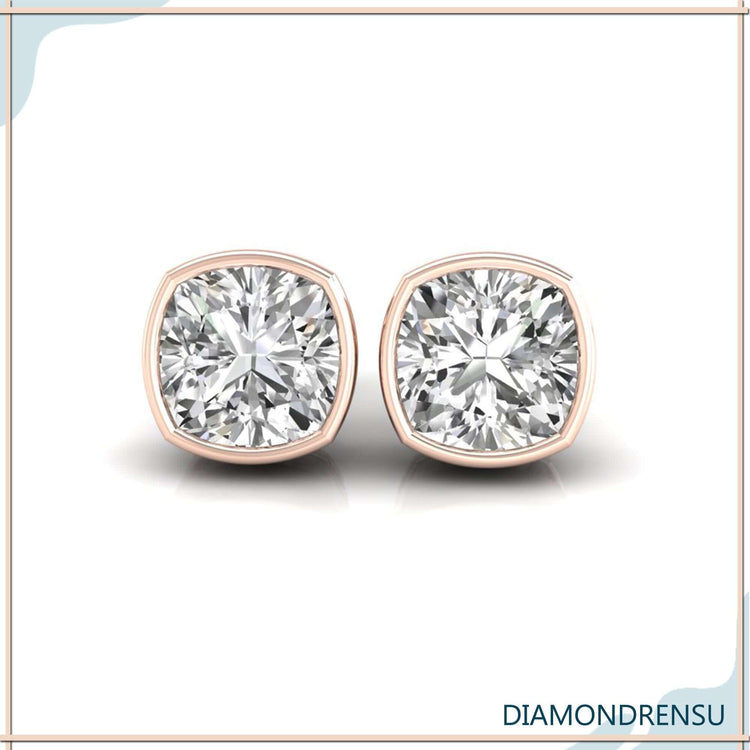 Rose gold cushion cut diamond earrings with bezel mount.
