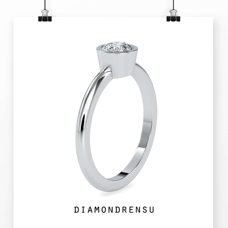 Yellow gold ring with round cut diamond in bezel setting.
