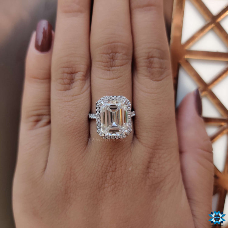 Halo engagement ring with emerald and round moissanite.
