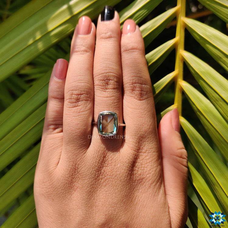 Cushion rose cut engagement ring featuring a vibrant cyan blue moissanite.
