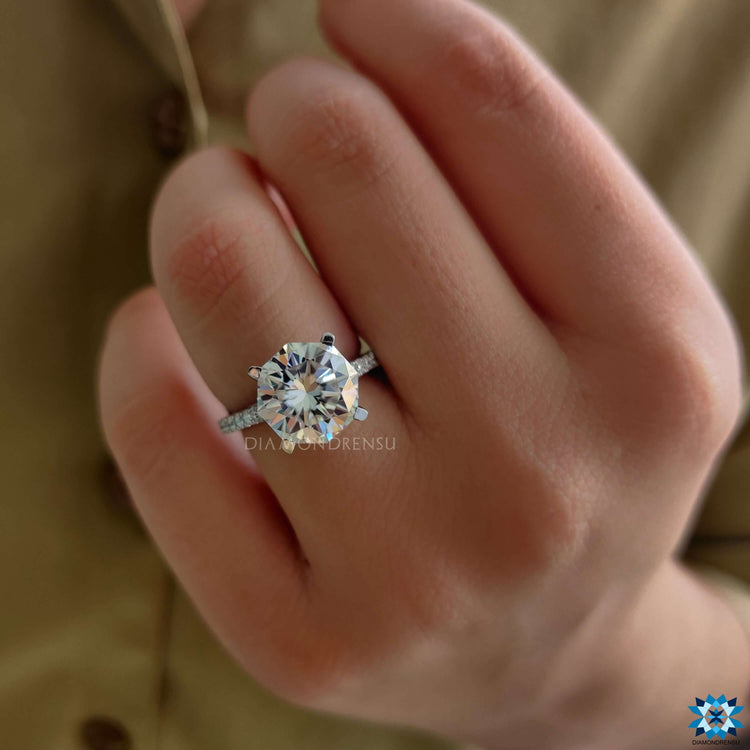 Elegant white gold moissanite ring with pave accent band.
