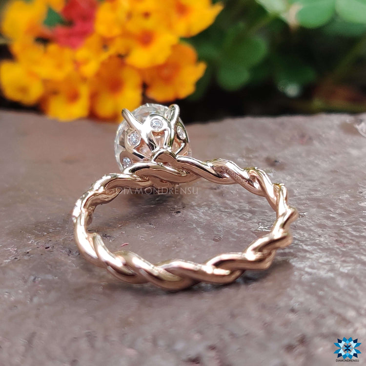 Oval cut moissanite ring with 4 claw prong and twisted band.
