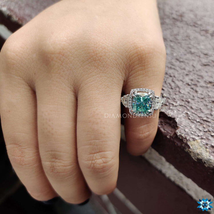 5 stone white gold ring with cushion cut blue moissanite.
