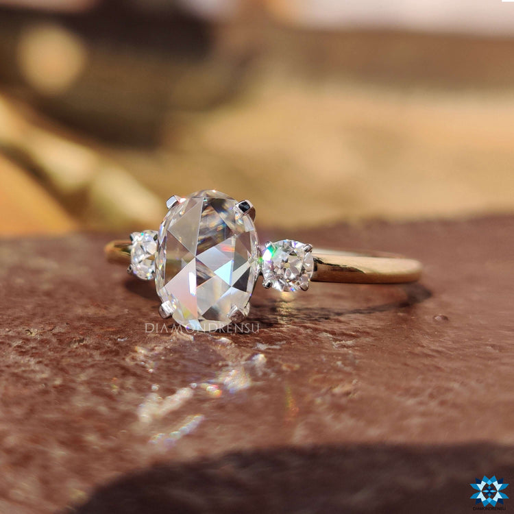 Oval center stone with round old European cuts on a custom three stone ring.
