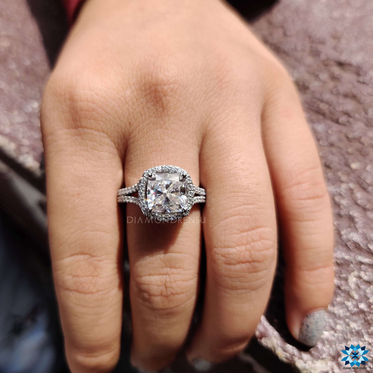 Cushion cut moissanite ring featuring a halo and bridge detail.
