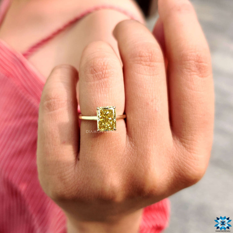 Yellow gold solitaire ring with radiant moissanite center.
