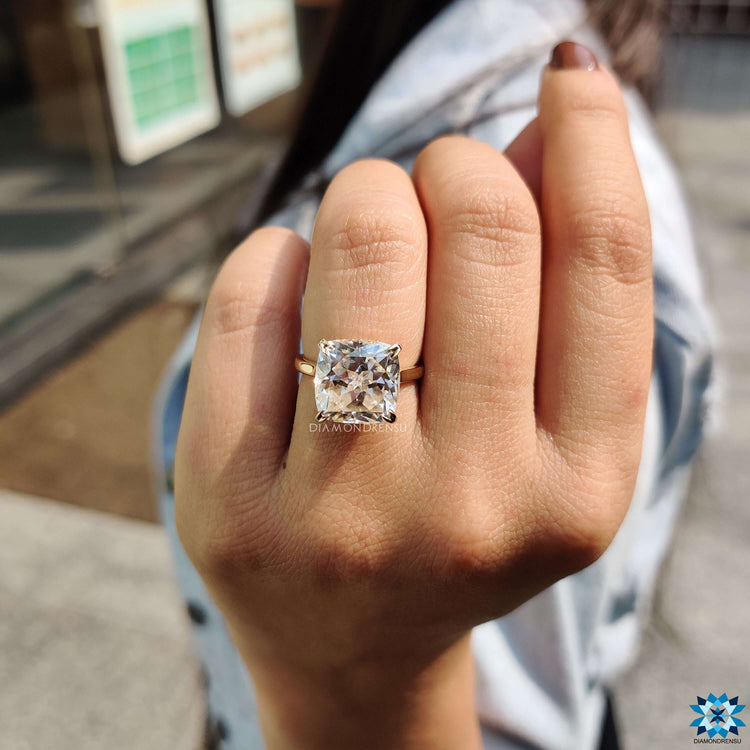 Yellow gold ring with cushion Rensu cut moissanite and hidden halo.
