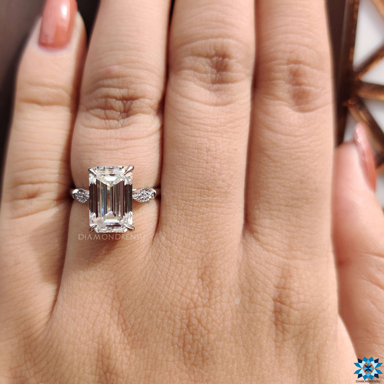 Elegant 4 claw prong ring with emerald cut center stone.
