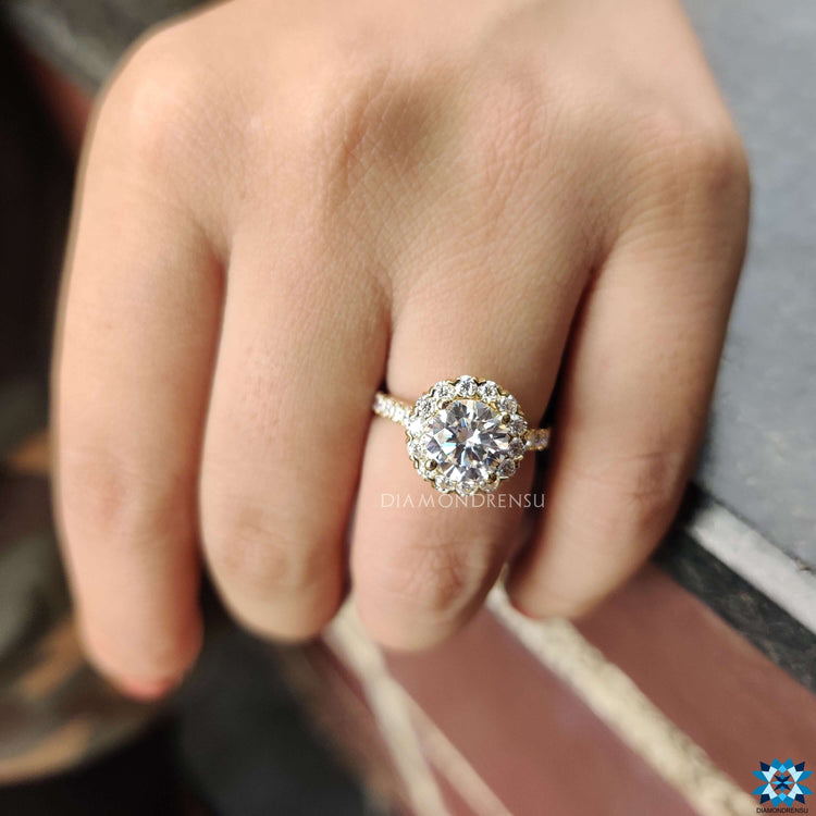 Prong setting ring featuring round moissanite and halo band.
