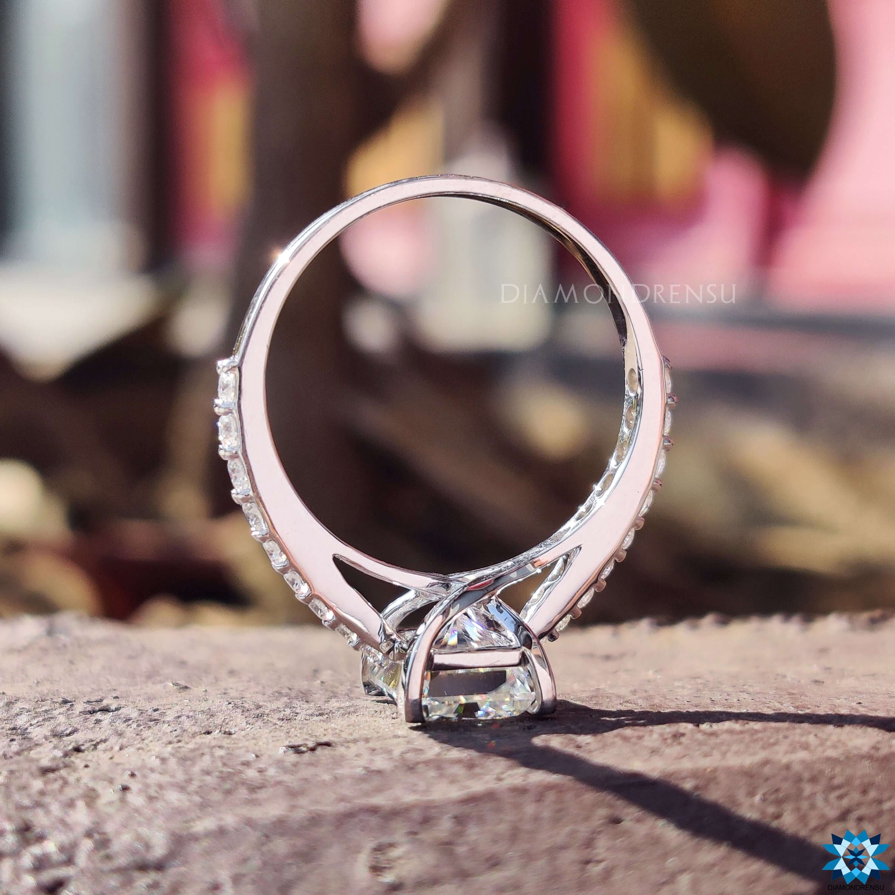 Handmade jewelry featuring a radiant cut engagement ring with diamond accents.