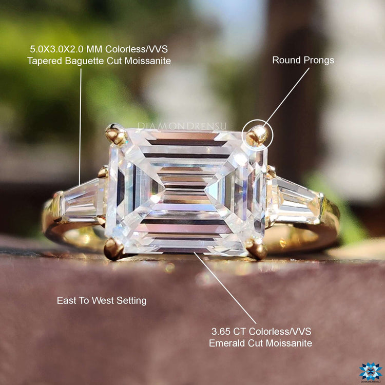 Prong set emerald cut center moissanite ring.
