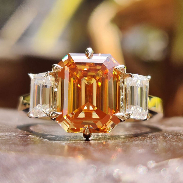 Emerald cut moissanite ring set in yellow gold.
