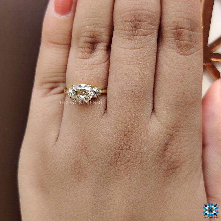 4 claw prong setting ring with a balanced layout of cushion and round old European cuts.
