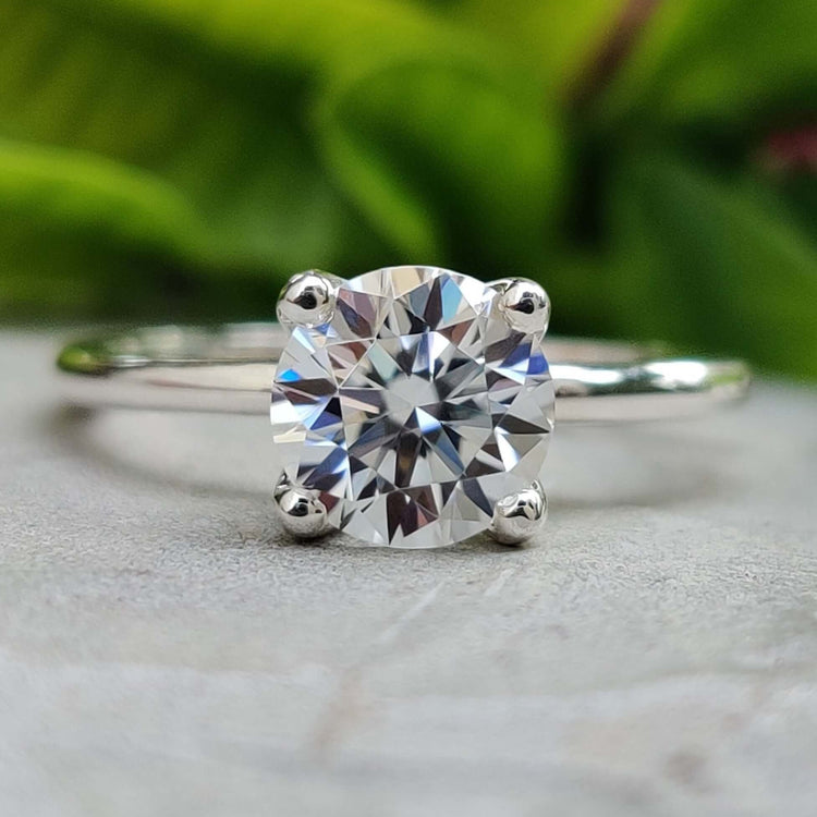 Round cut moissanite solitaire engagement ring in white gold.
