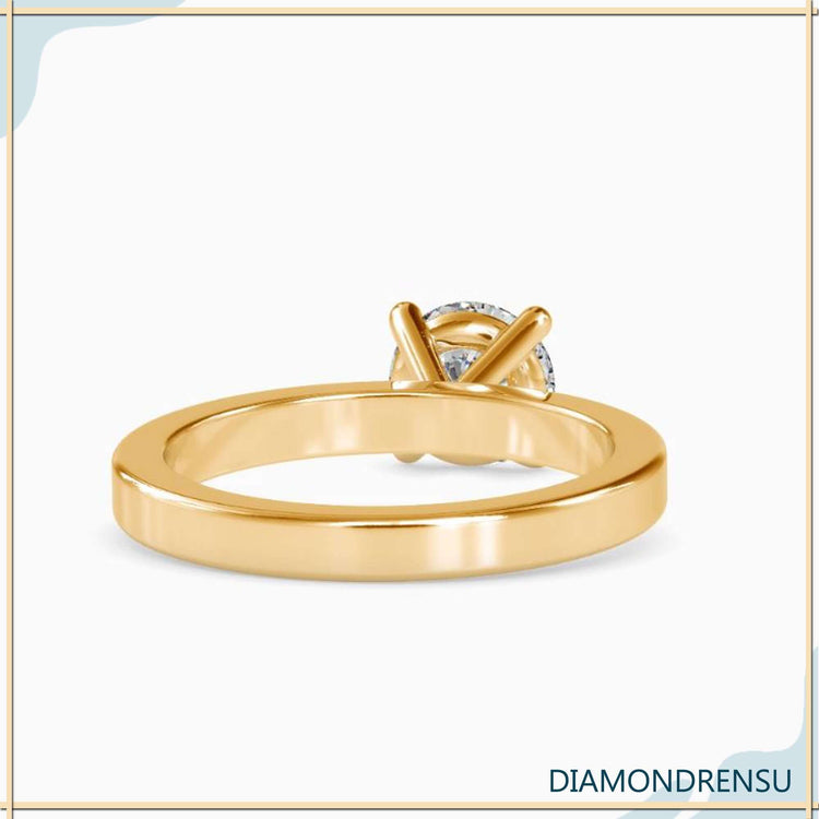 UK engagement ring with round diamond and gold finish.
